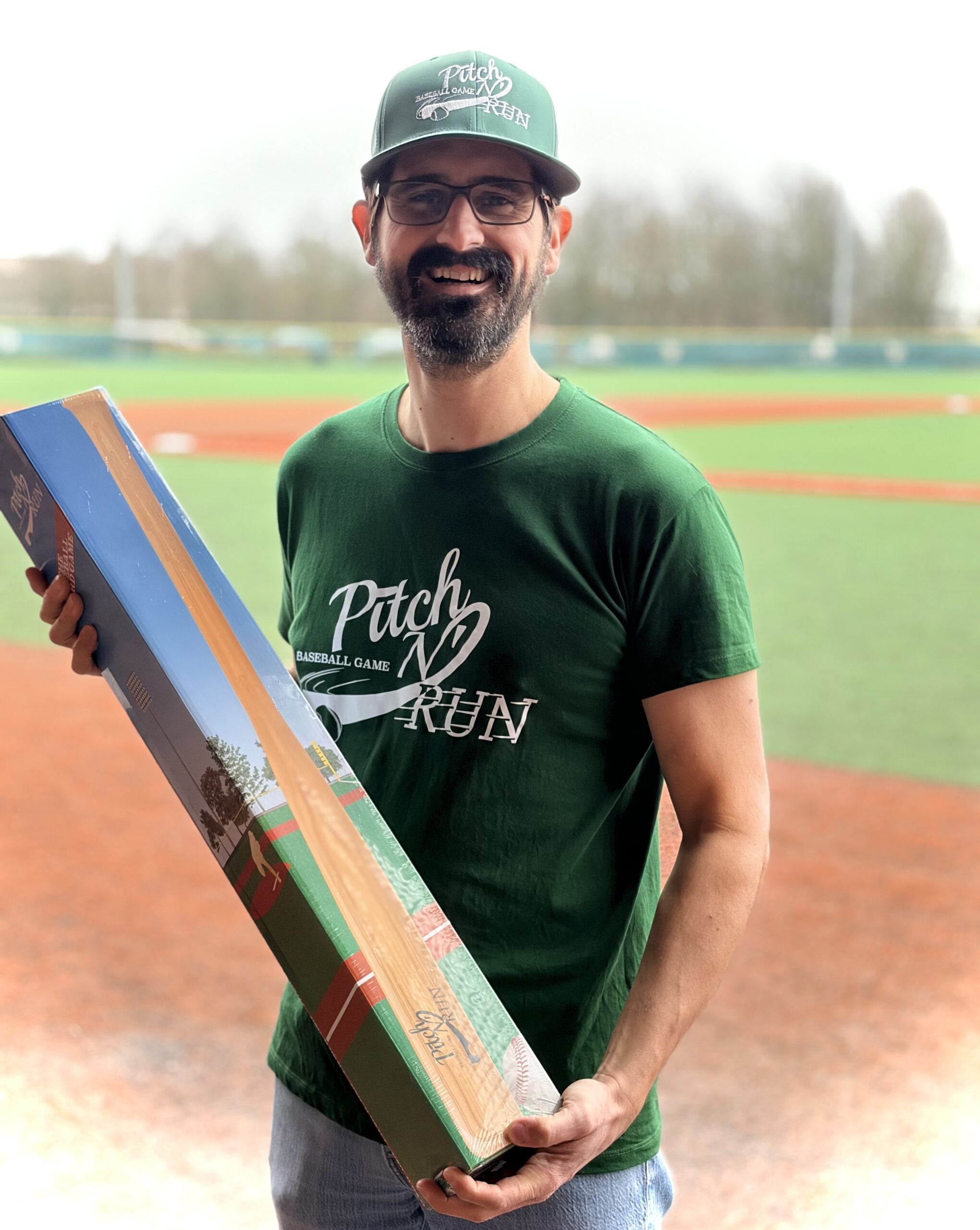 Raphaël Moreau in a Pitch N' Run jersey, holding the box on a baseball field